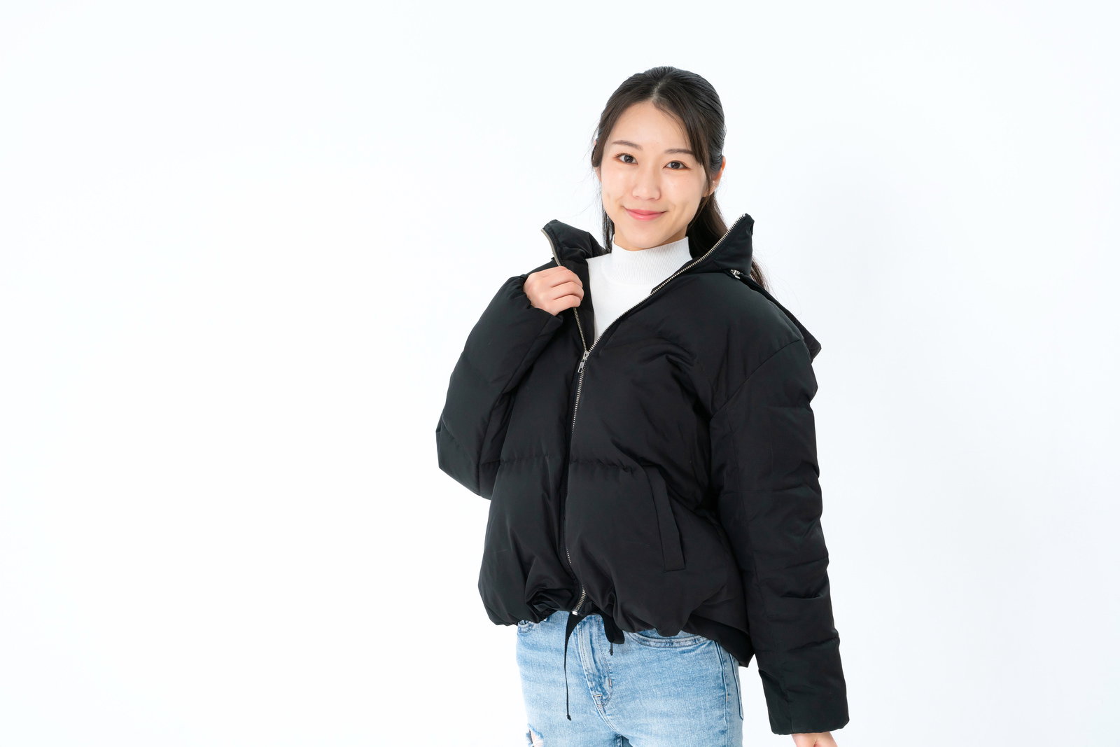 黒いダウンジャケットを着て親指を立てるポーズで笑顔の女性［モデル：SAKI］