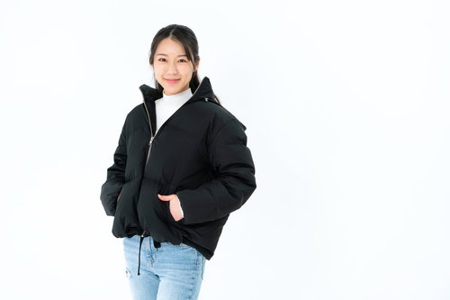 黒いダウンジャケットのポケットに手を入れる女性