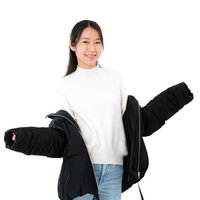 黒いダウンジャケットを肩出しする白いニットの女性の写真