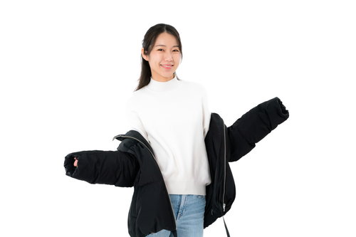 黒いダウンジャケットを肩出しする白いニットの女性