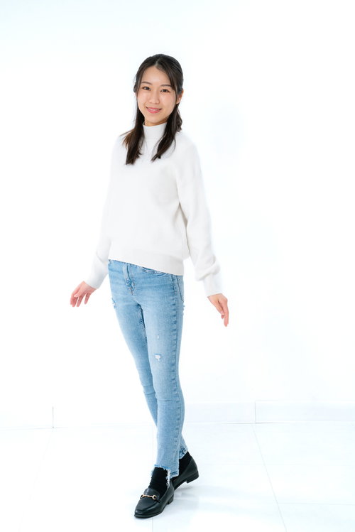 フィッティング中の白いニット姿の女性のカジュアルコーディネート