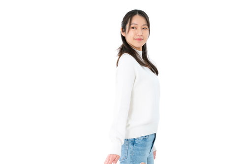 右方向を目視する女性のポージング、白トップスとデニムパンツの振り返るポーズ