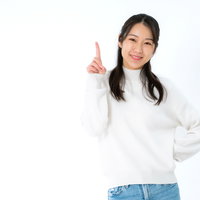 人差し指を立てるポイント解説の笑顔女性のビジネスポーズの写真