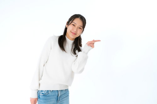 白いニットでこちらですよと右手で案内する女性