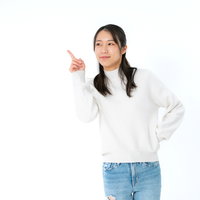 指を差してこちらを注目して下さいと微笑む女性の写真