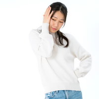 両手で頭を押さえて悩む女性のポーズの写真