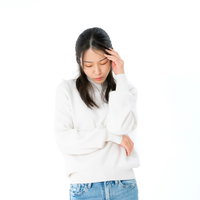 頭痛で考え込んでしまう女性、ストレスと疲労の写真