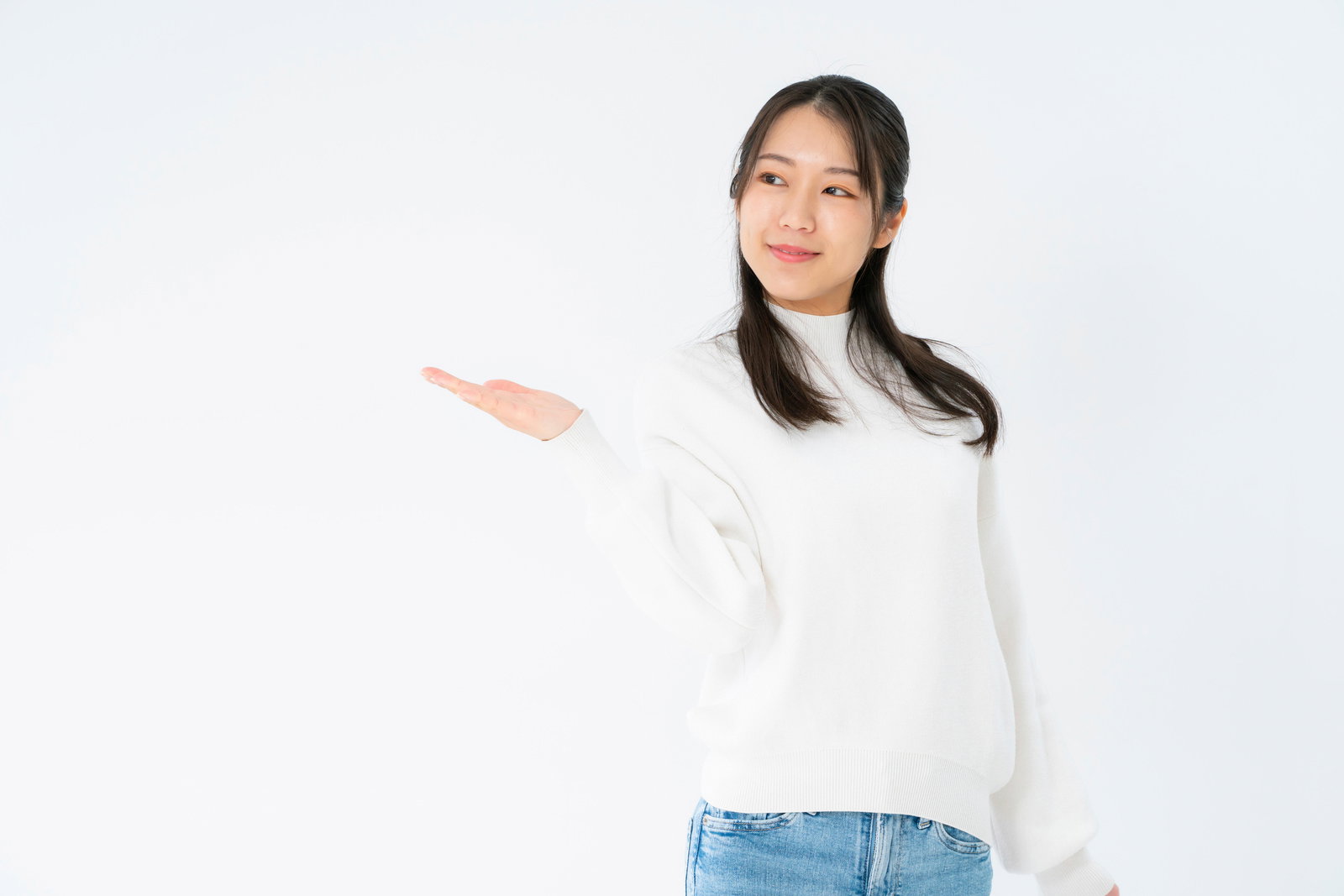 白いニットを着た女性が笑顔で右手を広げてアナウンスするポーズ［モデル：SAKI］