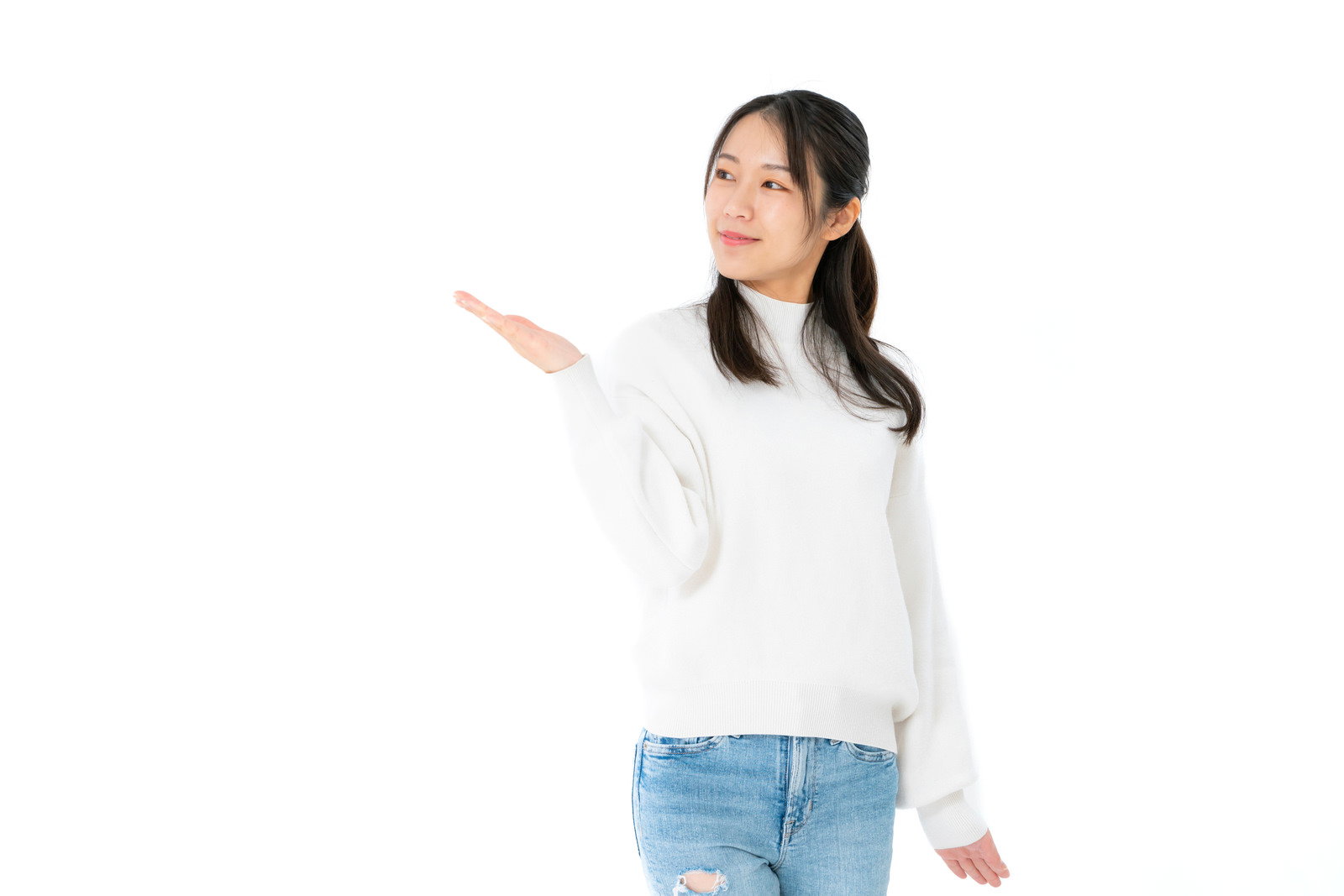 白いニットを着た女性が振り返りながら手を伸ばして案内するポーズ［モデル：SAKI］