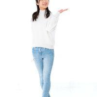 左手を説明するように広げる微笑む女性のポーズの写真