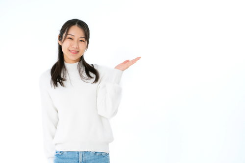 左手で案内する紹介ポーズをとる笑顔の女性