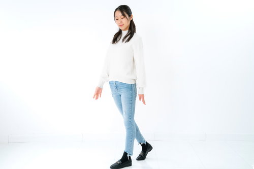 伏し目がちに立ち止まる女性のポーズ・ウォーキング