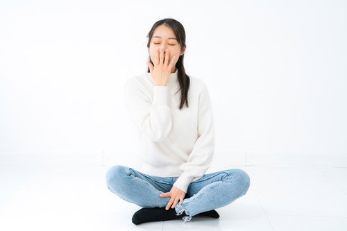 あくびが止まらない白背景の女性のポーズ集