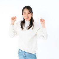 両手を上げてガッツポーズする笑顔の女性の写真