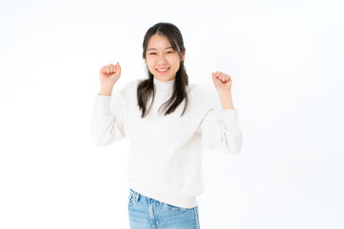 両手を上げてガッツポーズする笑顔の女性