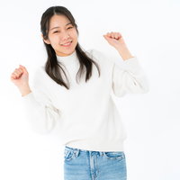 両手を上げてガッツポーズする心躍る女性のポートレートの写真