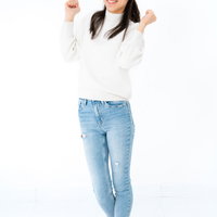 白背景でやったポーズをする立ち上がって大はしゃぎする女性の写真