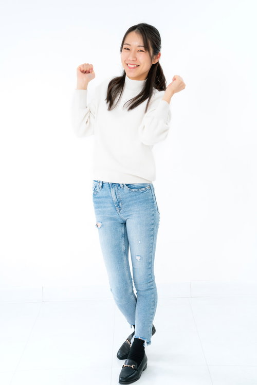 白背景でやったポーズをする立ち上がって大はしゃぎする女性