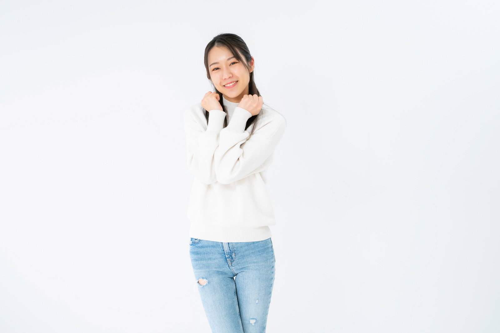 Young woman in white sweater doing a cute pose and smiling