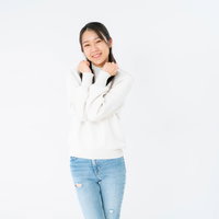 両手をグーにしてぶりっ子ポーズをとる女性の写真