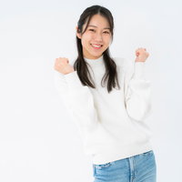 白背景で小さくガッツポーズして笑顔の女性の写真