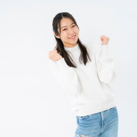 控えめにガッツポーズする女性の笑顔、喜びのポーズの写真