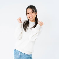 両手を上げてガッツポーズを取る笑顔の女性の写真