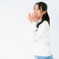 耳打ちする女性のポーズ、秘密めいたコミュニケーション表現の写真