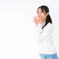 両手を口元に当てて大きな声でアピールする女性の写真