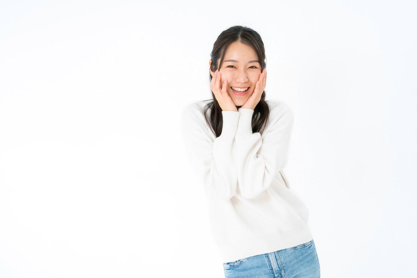 白いセーター姿で頬に手を添えて笑う女性［モデル：SAKI］
