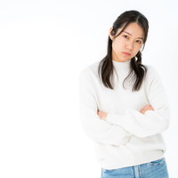 腕を組んでご機嫌ななめの女性、不機嫌で拗ねた表情の写真