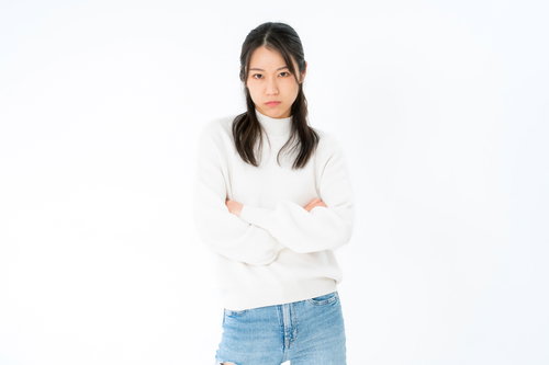 白いニットで腕を組んでご立腹の女性のポーズ