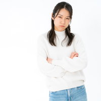 腕を組んで激おこの妻、白背景で怒りの表情を見せる女性の写真