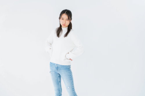 腰に手を当てて睨みつける女性のポーズ、不機嫌な表情