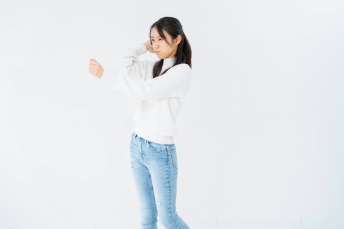 拳を握って怒る女性のポーズ