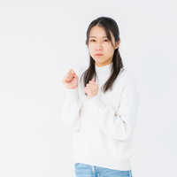 白背景でいじける女性のポーズ｜不機嫌な表情と仕草の写真