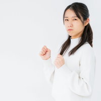 拳を握って不貞腐れる女性のポーズ集の写真