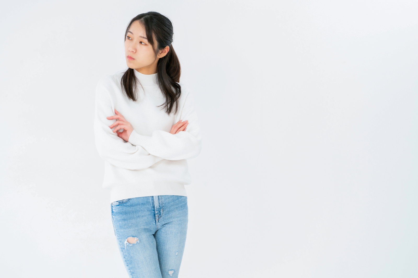白いシャツを着た女性が両腕を組んでそっぽを向いている［モデル：SAKI］