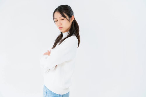 腕を組んで目をそらす女性のポーズ、不機嫌な表情