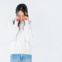 目元を押さえて泣く女性のポーズの写真