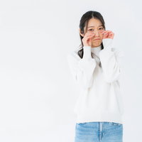 白いニットを着てウソ泣きする女性のポーズの写真