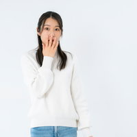 ギョッとして口を押さえる女性の写真