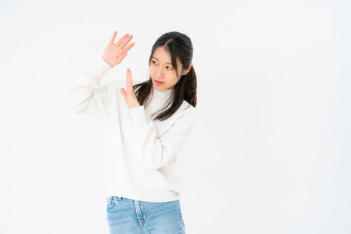 両手で身を守る女性