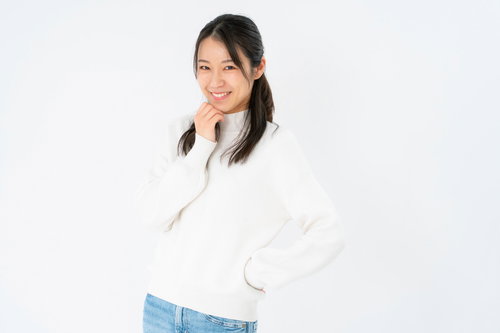 褒められると伸びる系女子のポーズ、白シャツで照れ笑い