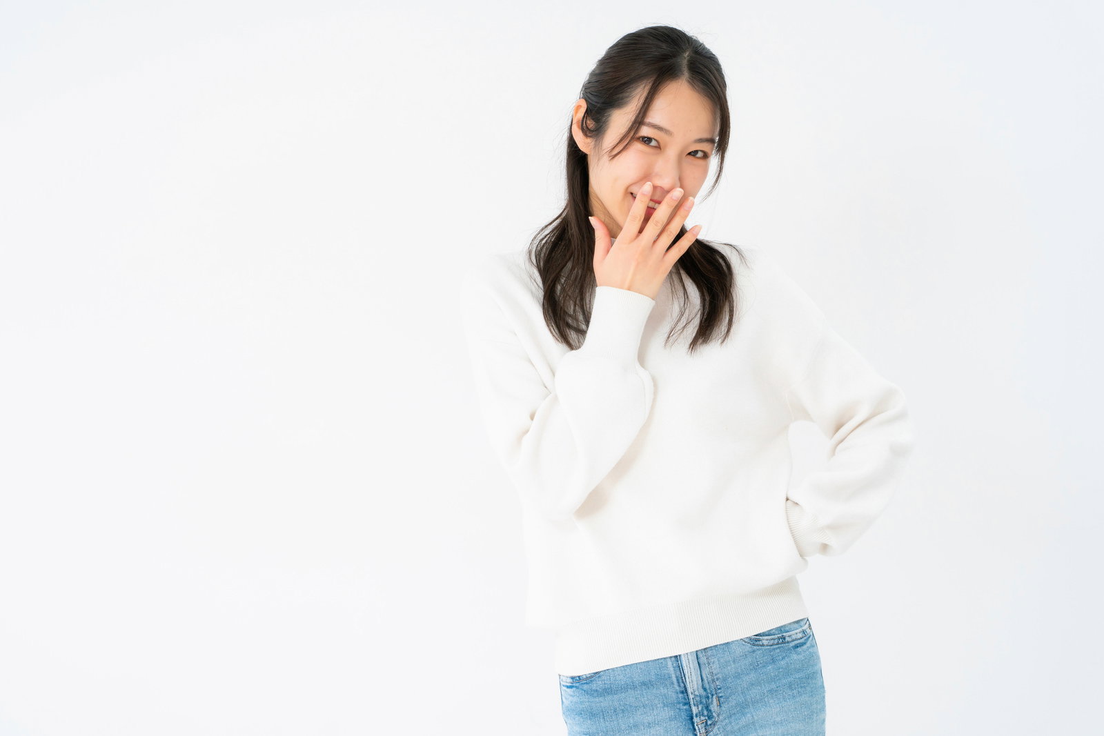 口に指を当てながらニヤリと笑う女性が斜め上を向いている［モデル：SAKI］