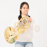 ホルンを演奏する女性（白背景）の写真