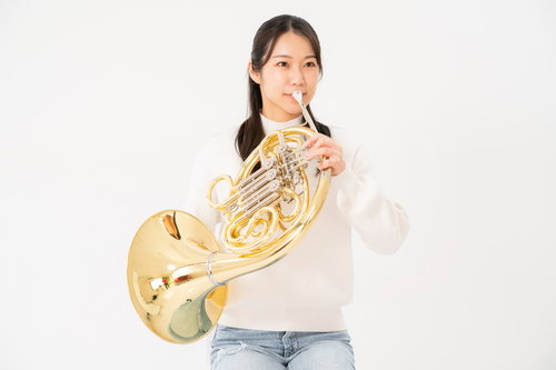 ホルンを演奏する女性（白背景）