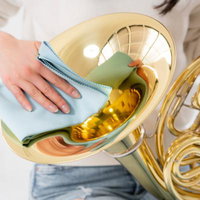 ホルンをメンテナンスする女性奏者の手元と楽器の写真