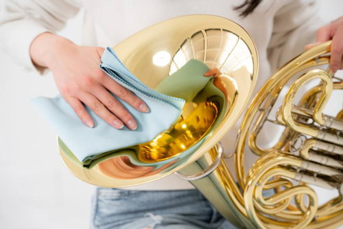ホルンをメンテナンスする女性奏者の手元と楽器