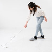 フローリングワイパーで床を掃除する女性の写真